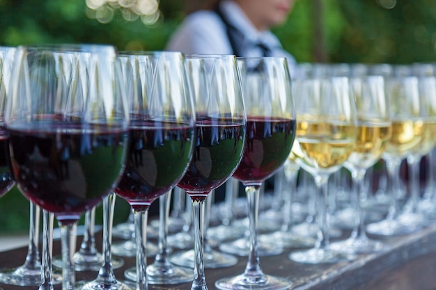 Bicchieri di vetro con vino rosso al bar, profondità di campo ridotta