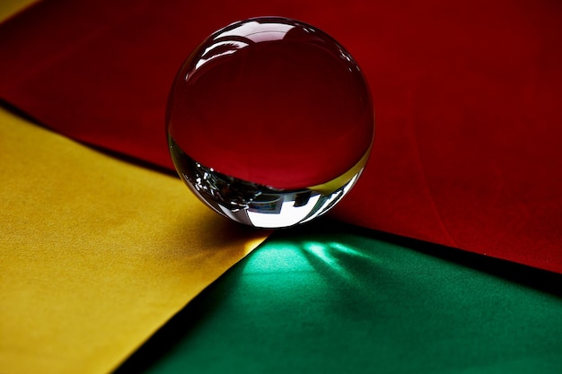 glass globe or drop of water on a background of yellow red and green velvet paper clean and shine