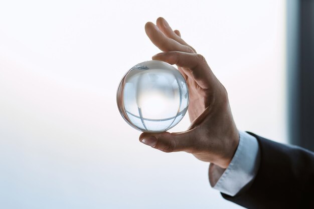 Glass globe on the palm of a business man closeup