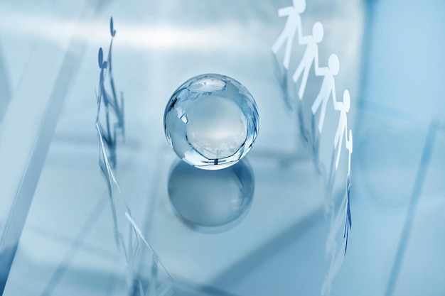 Glass globe and a paper business team on an office background