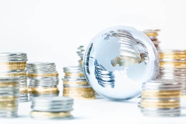 Photo glass globe and stacks of coins world money concept