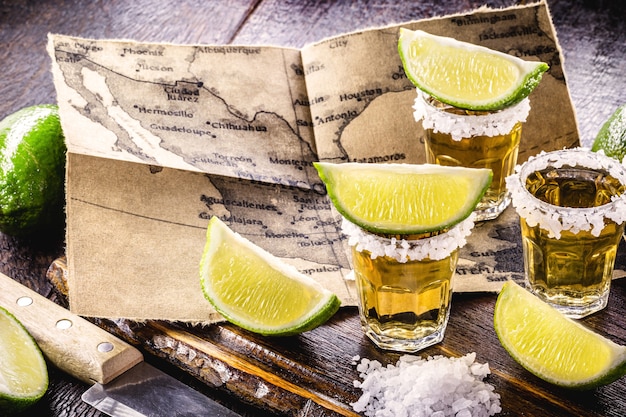 Photo glass of gold tequila with old mexico map in the surface