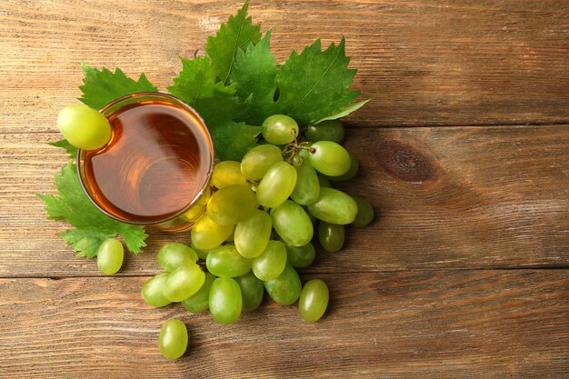 Glass of grape juice on wooden table top view