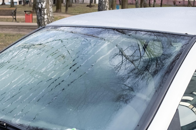 Glass of gray car with hoarfrost closeup