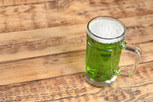 Foto bicchiere di birra verde su sfondo di legno celebrazione del giorno di san patrizio