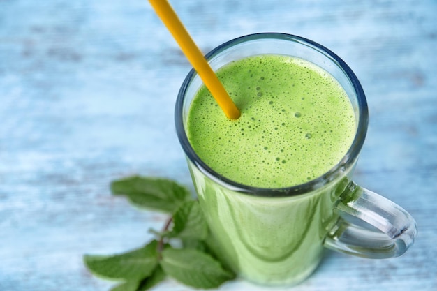 Glass of green healthy juice with mint closeup