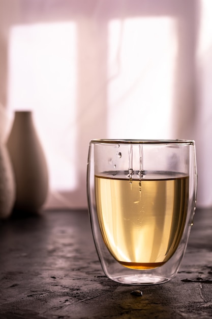 A glass of green tea with honey on a table