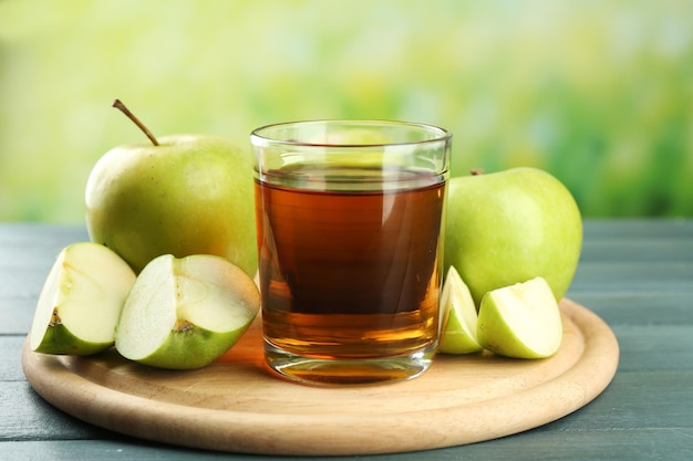 Glass of healthy fresh juice of apples on wooden background