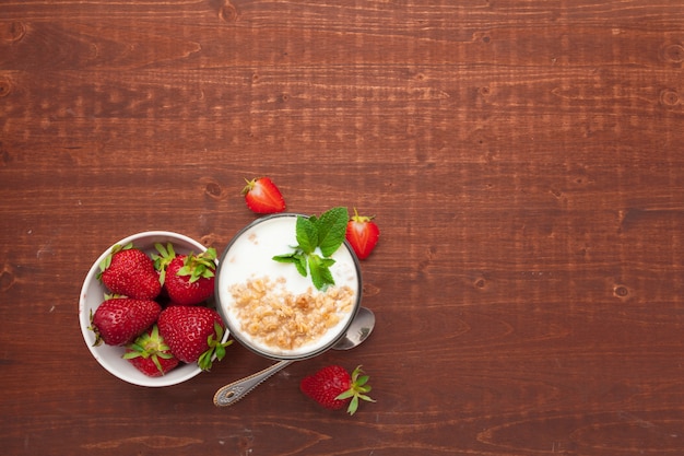 Photo glass of healthy strawberry yogurt with fresh berries on wooden table top view