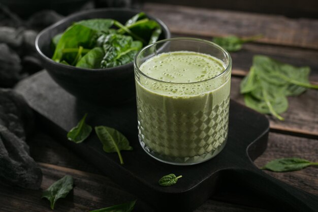 Glass of homemade healthy green smoothie with fresh baby spinach