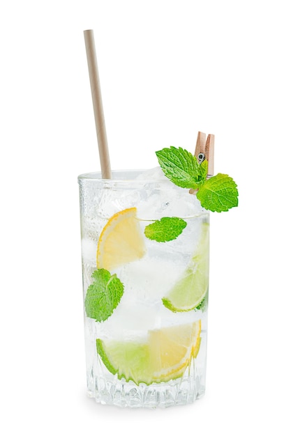 Glass of homemade lemonade with lime and lemon slices, ice and mint leaf with paper straw on white