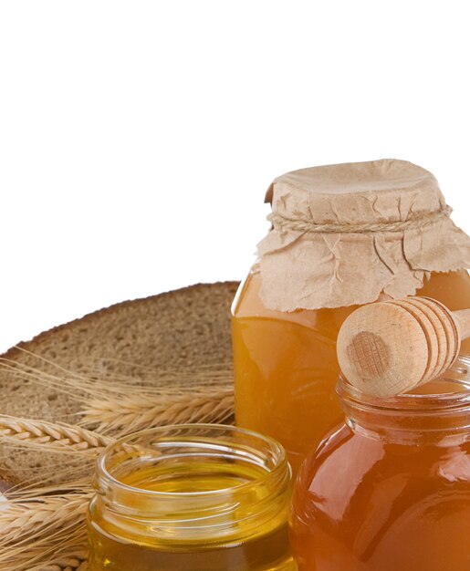 Glass of honey and bread isolated on white