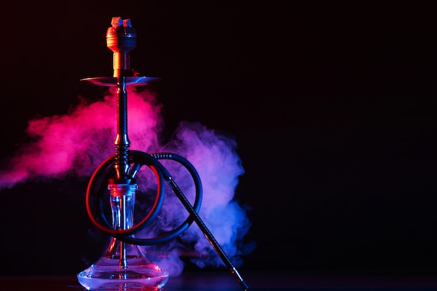 Glass hookah shisha with a metal bowl on the table