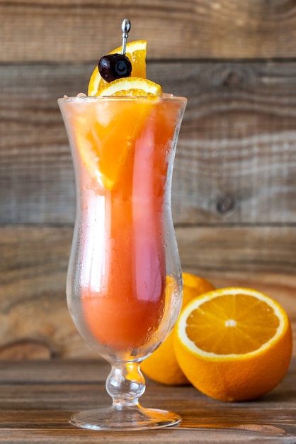 Glass of Hurricane cocktail on wooden background
