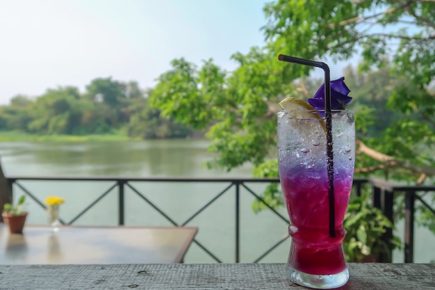 Photo a glass of ice blueberry soda with a slice of lemon.