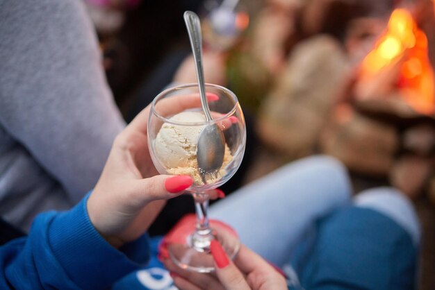 A glass of ice cream in a female hand with a beautiful manicure