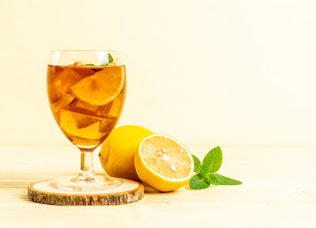 Glass of ice lemon tea and mint leaves