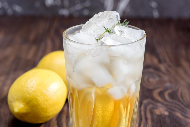 나무 테이블에 레몬을 넣은 아이스 티 한 잔 클로즈업
