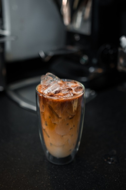 Bicchiere di caffè freddo con latte sul tavolo