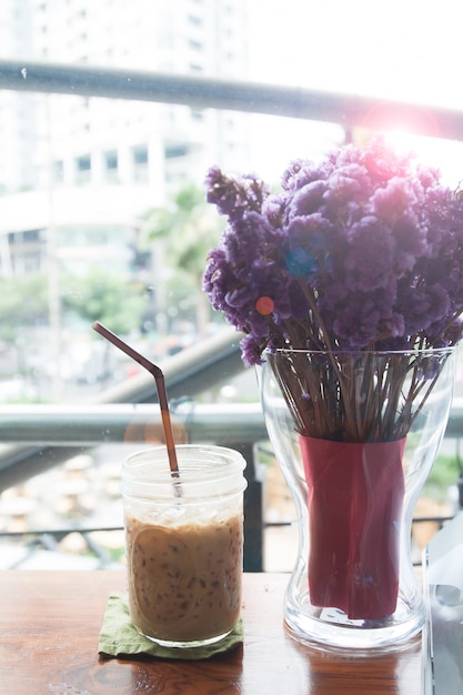 紫色の花と氷のコーヒーのガラス