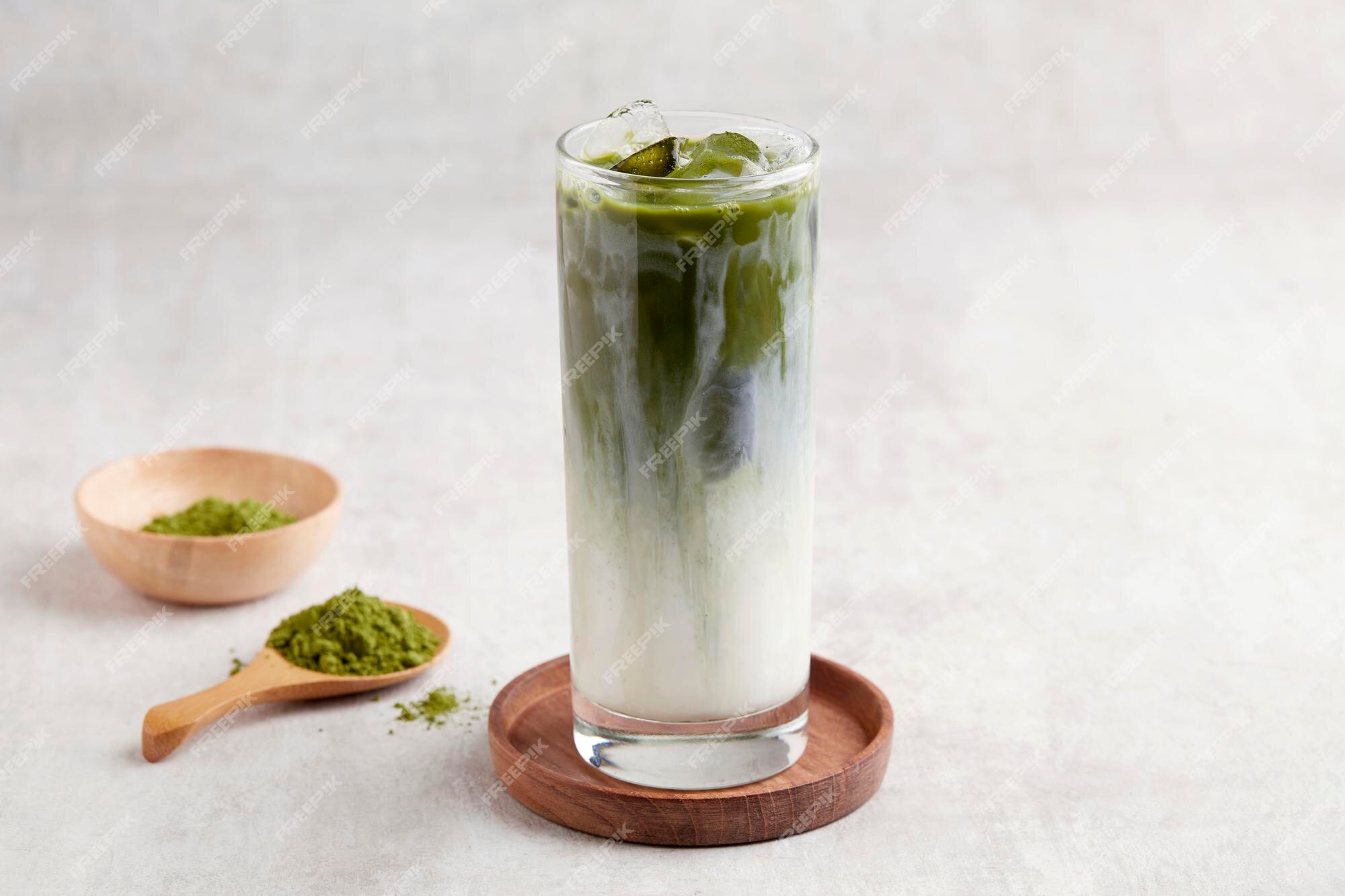 Premium Photo  Iced green tea matcha dalgona in two glasses with a straw  and a bowl of matcha powder for cooking on a wooden tray white background  space for text