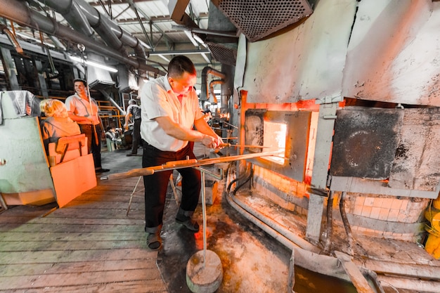 Glass industry workers working with manufacture equipment on production of glass 