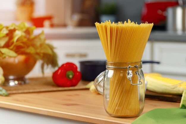 Glass jar of dry pasta on kitchen counter