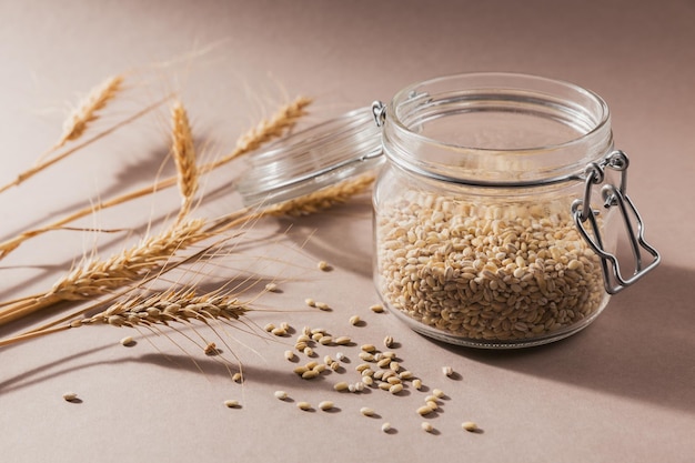 glass jar of dry raw broken pearl barley cereal grain