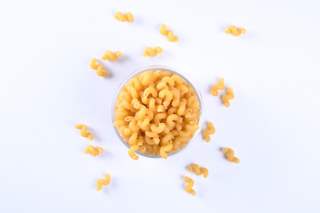 Glass jar filled with dry rotini yellow pasta isolated