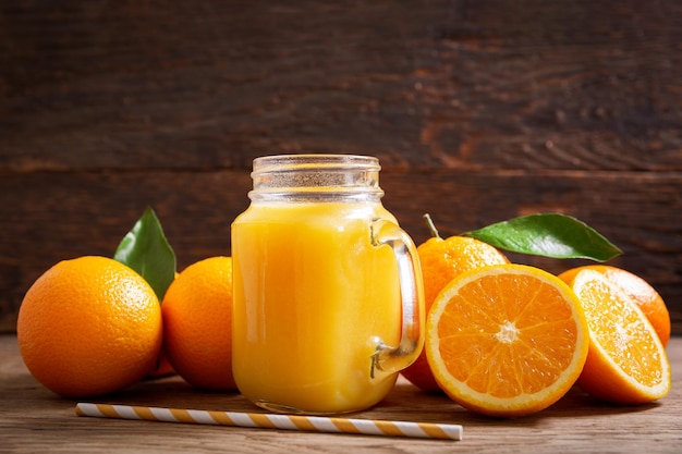 Glass jar of fresh orange juice with fresh fruits