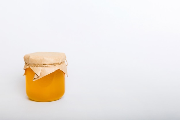 Glass jar full of honey on a colored background Honey Bottle MockUp