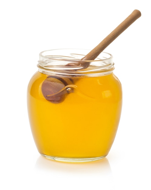 Glass jar full of honey and stick isolated on white