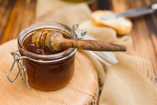 Photo glass jar full of honey with honey spoon