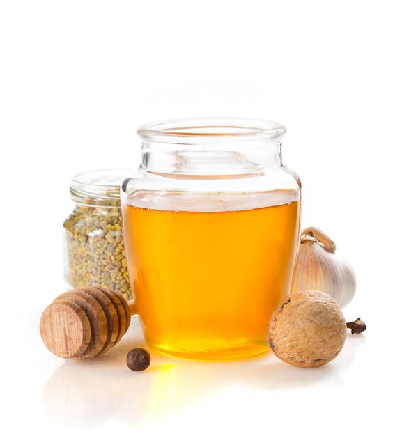 Glass jar of honey isolated on white