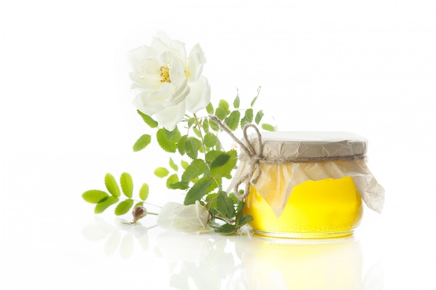 Glass jar of honey on white