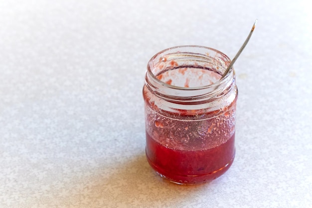 Glass jar of jam that has almost been eaten