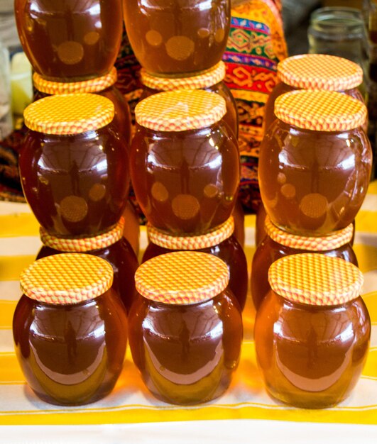 写真 新鮮な蜂蜜がたっぷり入った蓋付きのガラス瓶