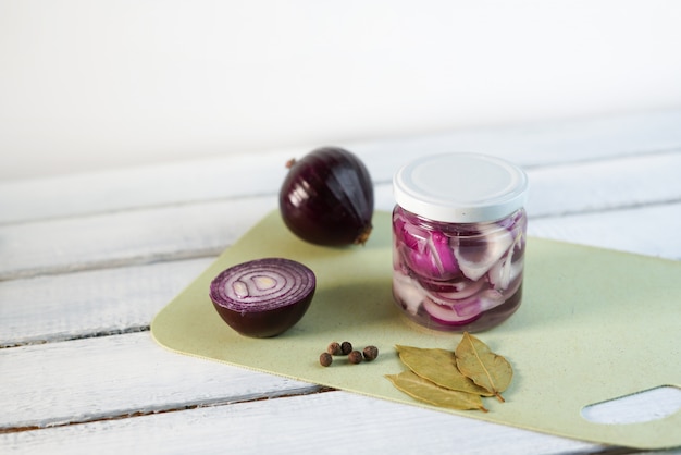 Photo glass jar of pickled onions on white wood background