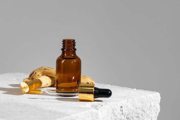 Glass jar of skincare serum on concrete block close up