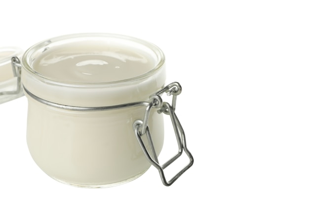 Vaso di vetro di yogurt con panna acida isolato su bianco