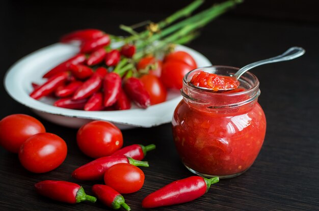 Glass jar of tomato sauce with fresh ingredients