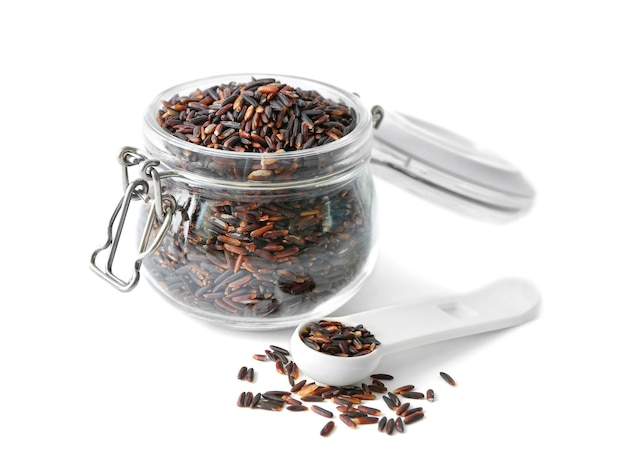 Glass jar with brown rice on white background