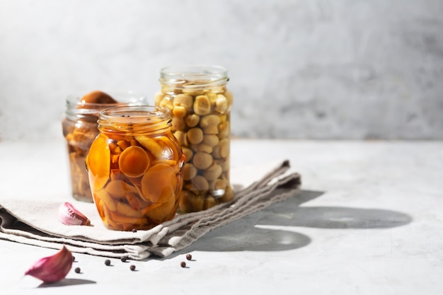 Glass jar with canned mushrooms with garlic and pepper.