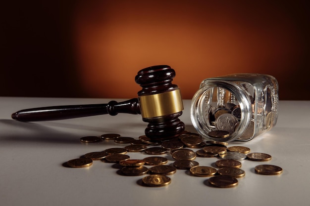 테이블에 동전과 나무 망치가 있는 유리 항아리. 법률 개념입니다.