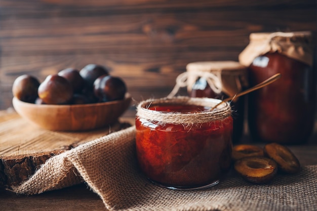 Barattolo di vetro con deliziosa marmellata di prugne fatta in casa sul tavolo