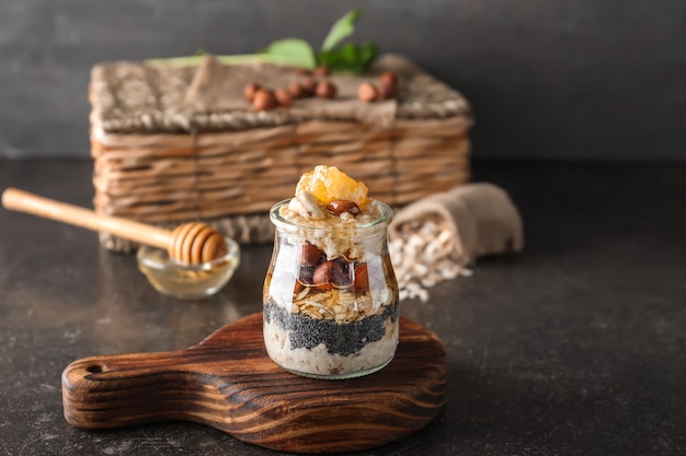 Glass jar with delicious oatmeal dessert on table