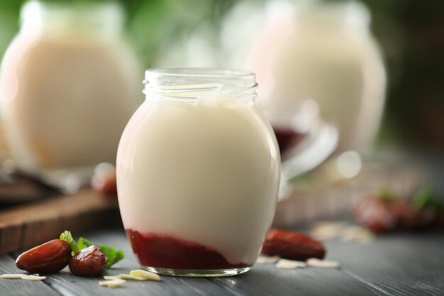 Foto vaso di vetro con delizioso yogurt sul tavolo di legno