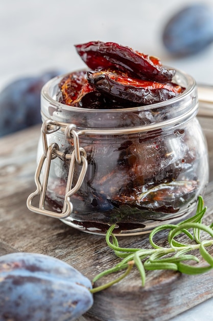 Glass jar with dried plums closeup