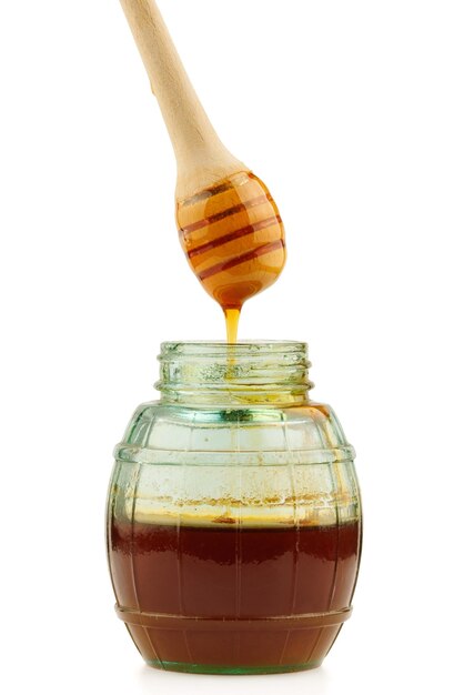 Glass jar with honey and wooden spoon