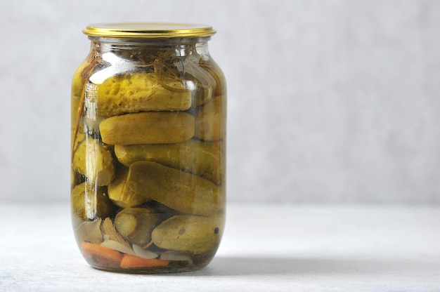 Foto vaso di vetro con un coperchio di ferro con cetrioli in scatola